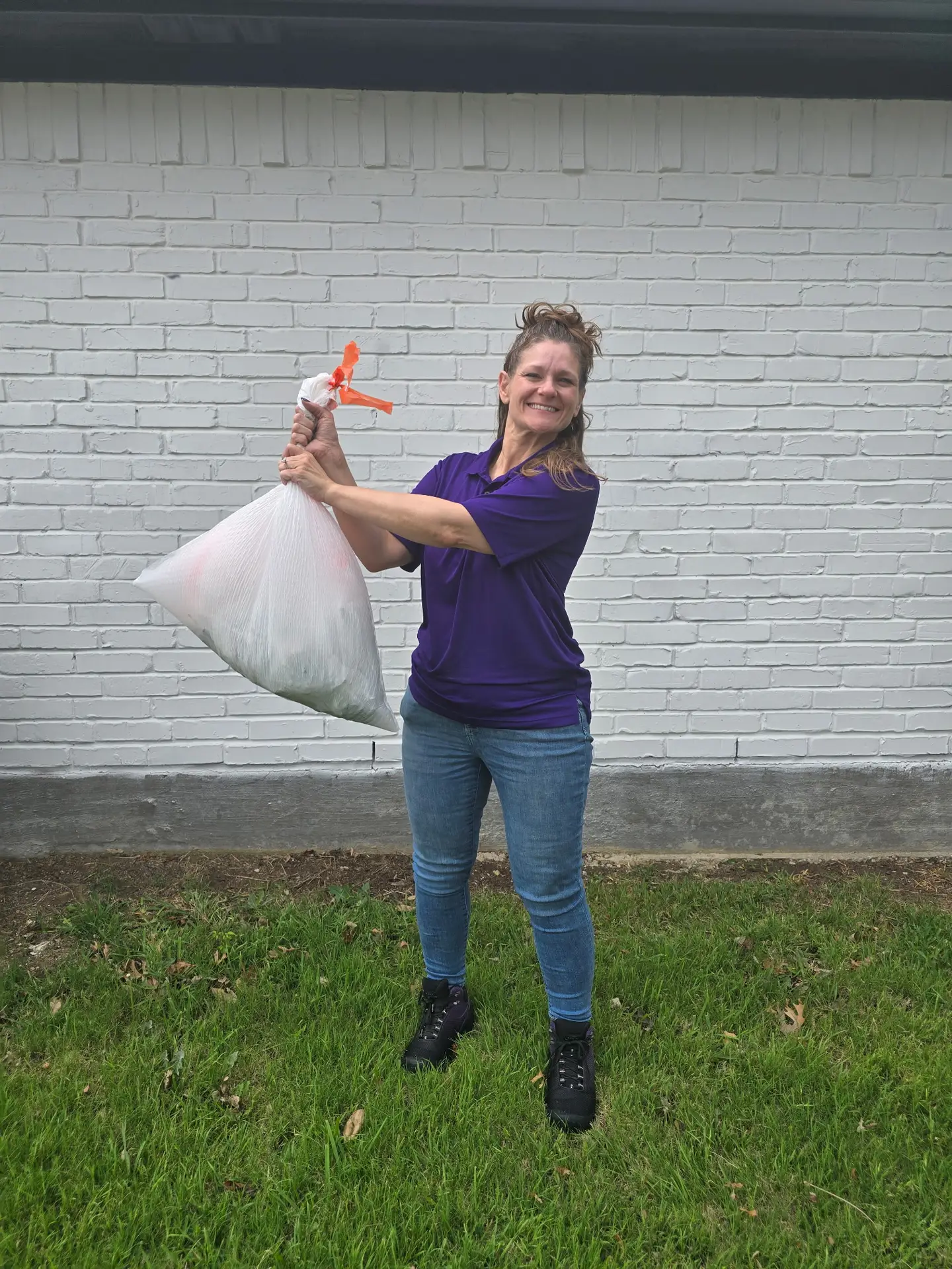 Pooper Scooper Simply Scoop technician scooping pet waste from a residential backyard lawn.